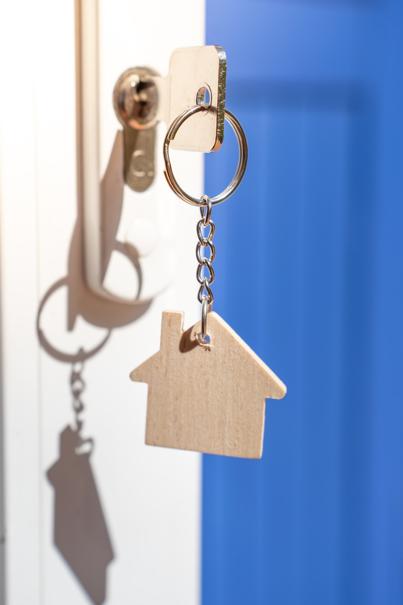 Opening door to a new home with key and home shaped keychain. Property and new home concept