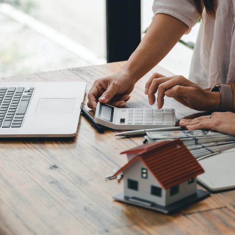 Couple hand use calculating interest, taxes and profits to invest in real estate and home buying